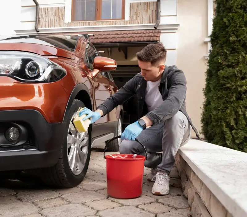 Lavage auto à domicile Villiers-le-Mahieu : professionnel intervenant sur un véhicule